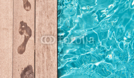Traces de pieds nus au bord d'une piscine