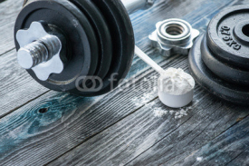 Fototapety Classic dumbbell with protein powder on rustic wooden table