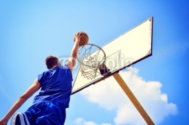 Naklejki Basketball player in action flying high and scoring