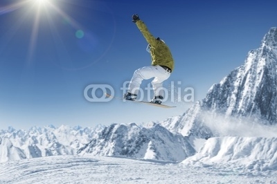 Jumping Snowboarder in alpine mountains