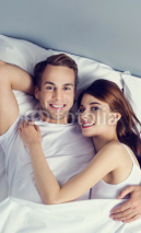 Happy young couple on the bed