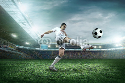 Soccer player with ball in action outdoors.