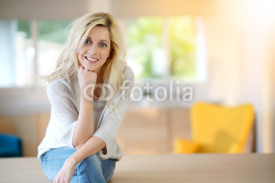 Blond woman with blue eyes sitting on table