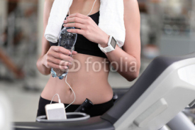 Slim girl holding a bottle of water after workout