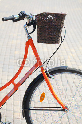 road bike with a wicker basket of orange on the steering wheel