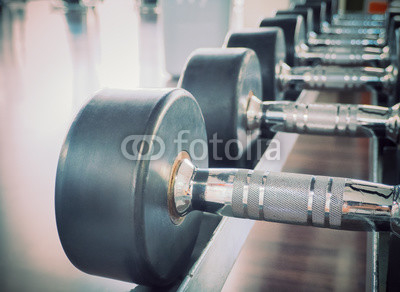 Dumbbell in at the gym room /Color filter and selective focus