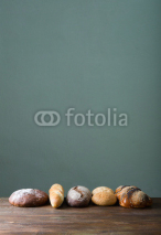 Obrazy i plakaty Fresh baked bread at wooden table
