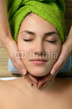 Naklejki Young beautiful woman in spa gets a facial massage