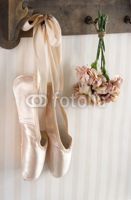 Pair of ballet pointe shoes hanging from a rack
