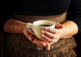 Naklejki Hands of senior woman holding cup of coffee