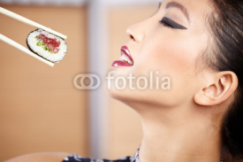 Fototapety beautiful asian woman eating sushi with chopsticks
