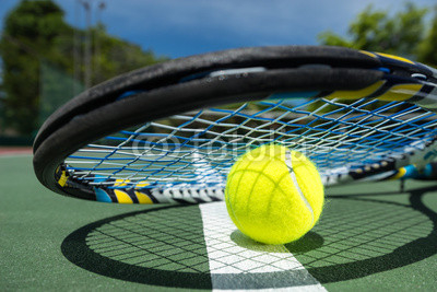 view of tennis racket and balls on the clay tennis court