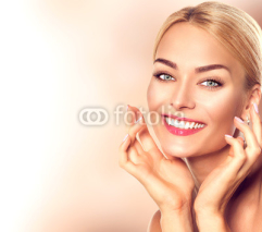 Beauty woman portrait. Beautiful spa girl touching her face and smiling. Perfect fresh skin