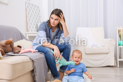 Depressed young woman with cute baby at home