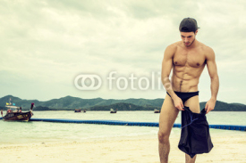 Handsome young man at the beach. Horizontal outdoors shot. 
