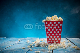 Box of popcorn on blue background.