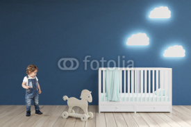 Boy in a babyâ€™s room, blue walls