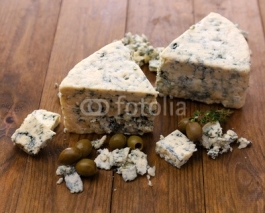 Naklejki Tasty blue cheese with olives, on wooden table
