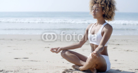 Naklejki Woman Meditating On Beach In Lotus Position
