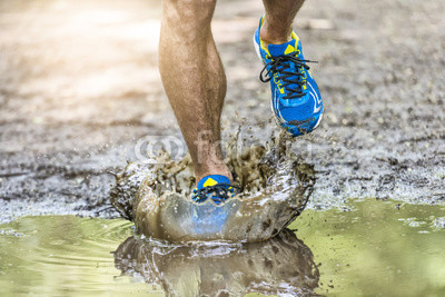 Running man walking in a puddle, splashing his shoes. Cross 