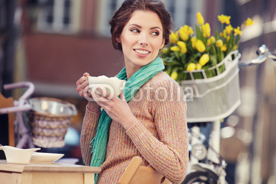 Woman drinking coffee in a cafe on the streets of Paris