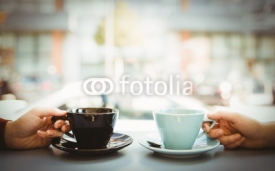 Friends holding cup of coffee