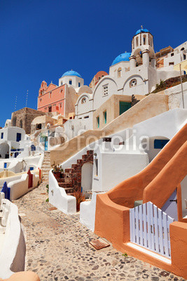 Typical Santorini street with houses and churches around