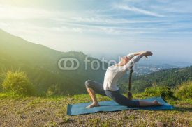 Naklejki Woman does yoga asana Anjaneyasana in mountains