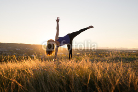 Fototapety Woman doing yoga half moon pose during sunset