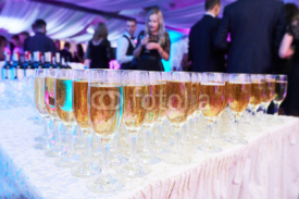 glasses with white sparkling wine in row at restaurant event