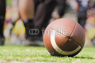 American football ball and de-focused players.