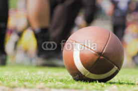 Fototapety American football ball and de-focused players.