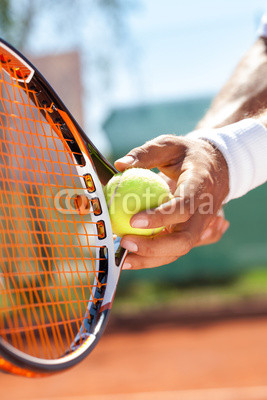 hand with tennis ball and racket
