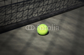 Fototapety Tennis ball on the court with the net on the background