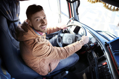 Driver in cabin of big modern truck