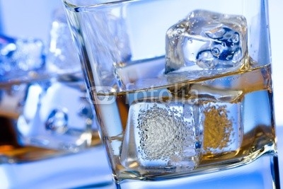 two glasses of alcoholic drink with ice on disco blue light