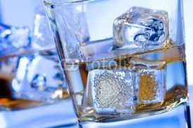 Fototapety two glasses of alcoholic drink with ice on disco blue light