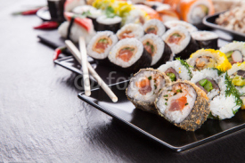 Fototapety Delicious sushi pieces served on black stone