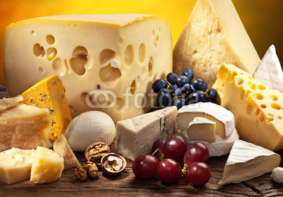 Different types of cheese over old wooden table.