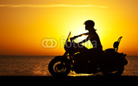 Naklejki Woman biker over sunset