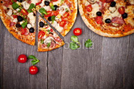Naklejki Delicious italian pizzas served on wooden table