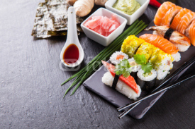 Obrazy i plakaty Delicious sushi pieces served on black stone