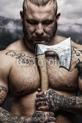 Portrait of tattooed male with vikings axe.