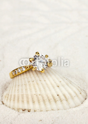 macro photo of jewelry ring with big diamond on white sand backg