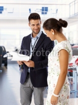 Salesman at car dealership with keys and papers