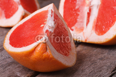 pieces of red grapefruit on the old wooden table closeup