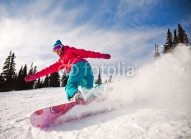 Fototapety Snowboarder jumping through air with  blue sky in background