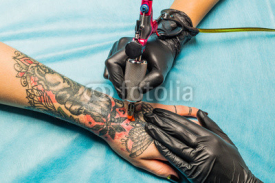 Fototapety Tattooist demonstrate the process tattoo on hand