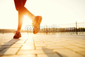 Obrazy i plakaty Runner feet running on road closeup on shoe. woman fitness sunri