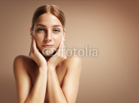Naklejki young woman touching her face and looking stright